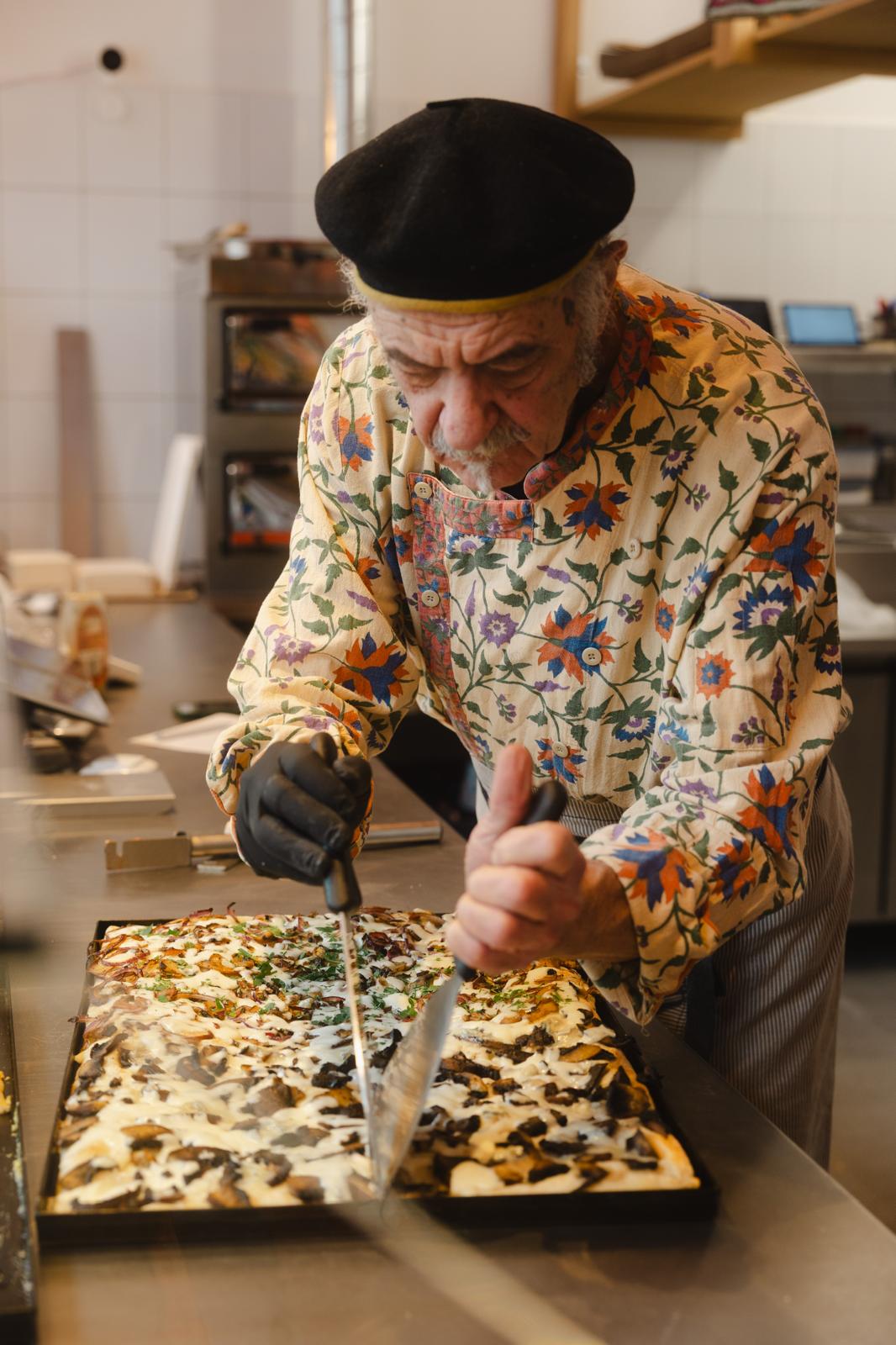 Pizzarama founder cutting freshly baked pizza