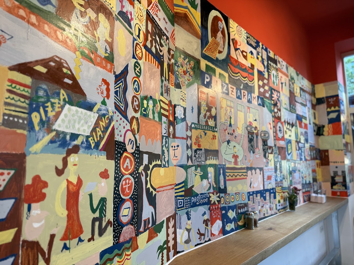 The colourful hand-painted art wall inside Pizzarama