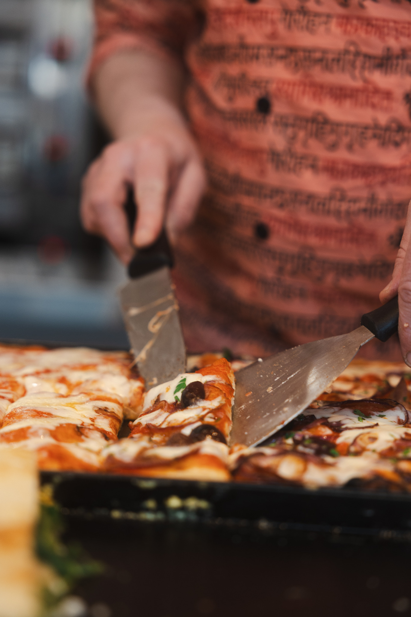 Pizzarama slices being cut for serving